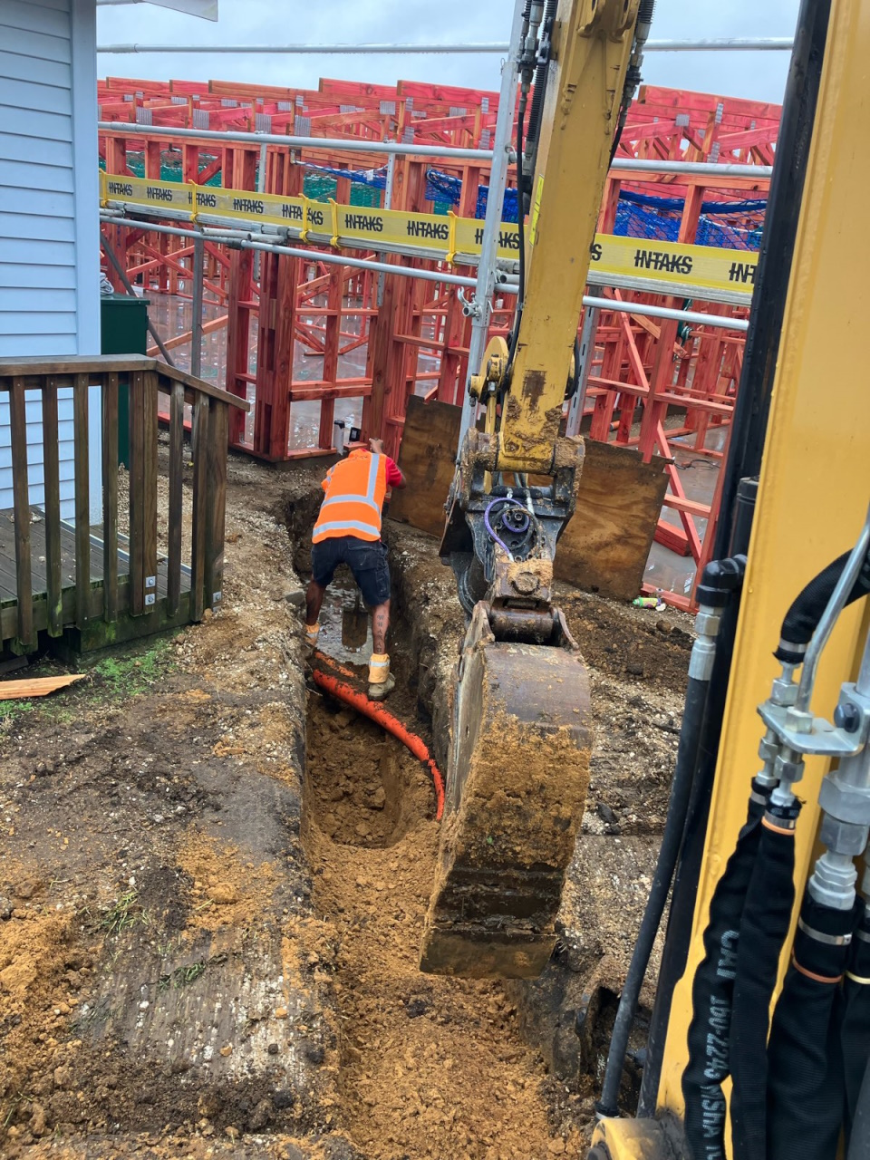 residential drain laying with digger digging trench